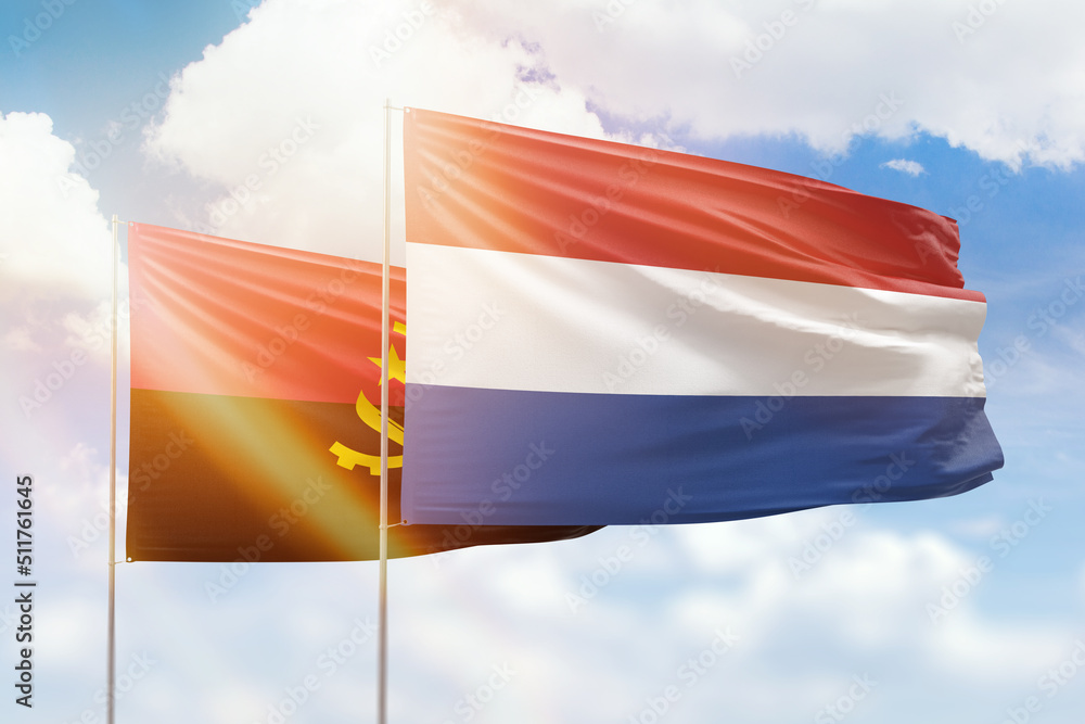 Sunny blue sky and flags of netherlands and angola Sunny blue sky and flags of netherlands and angola