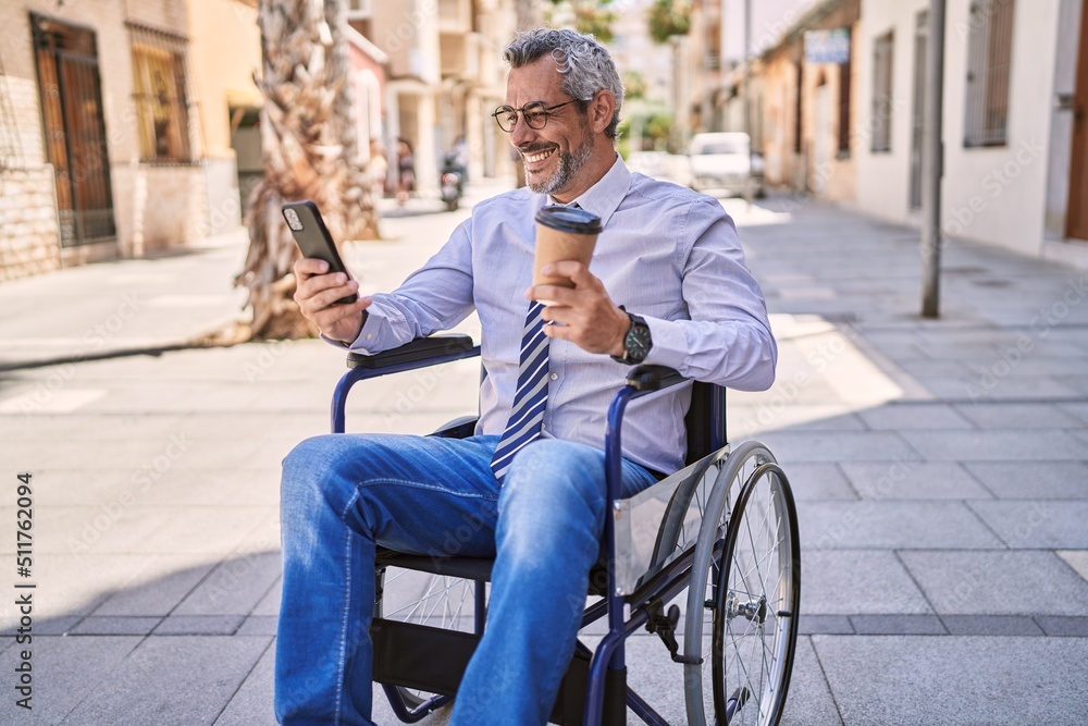 Middle age hispanic man sitting on wheelchair using smartphone at street Middle age hispanic man sitting on wheelchair using smartphone at street