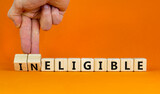 Eligible or ineligible symbol. Businessman turns wooden cubes and changes words Ineligible to Eligible. Beautiful orange table orange background. Business eligible or ineligible concept. Copy space.