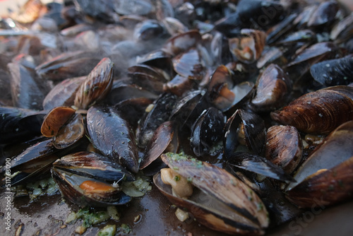 baking mussels on frying pan at summer day