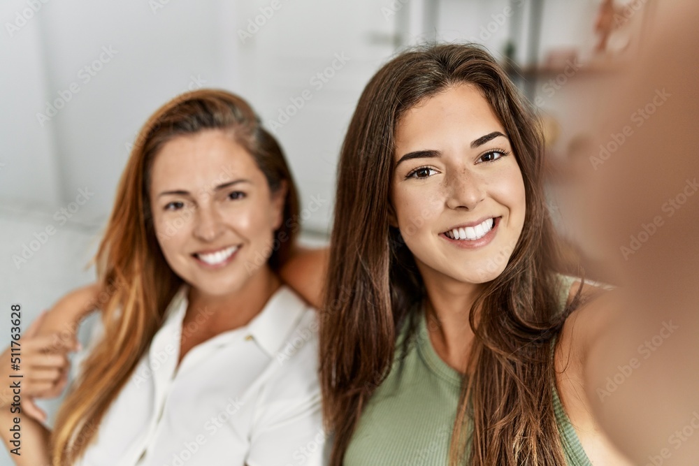 Mother and daughter smiling confident and hugging each other making selfie by the camera at home Mother and daughter smiling confident and hugging each other making selfie by the camera at home