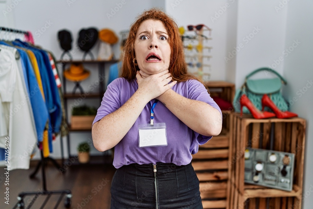 Young redhead woman working as manager at retail boutique shouting and suffocate because painful strangle. health problem. asphyxiate and suicide concept. Young redhead woman working as manager at retail boutique shouting and suffocate because painful strangle. health problem. asphyxiate and suicide concept.