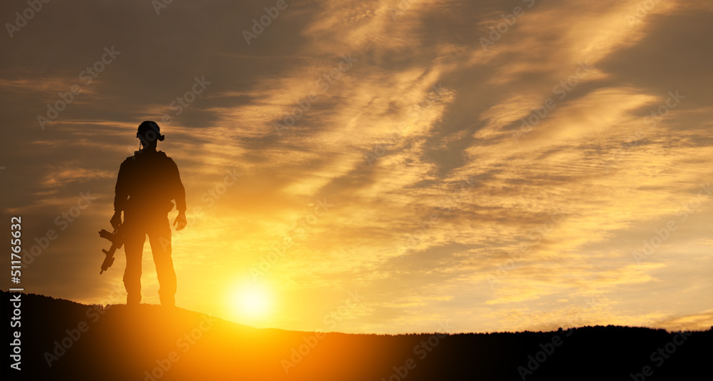 Silhouette of soldier standing against the backdrop of a sunset. Greeting card for Veterans Day, Memorial Day, Independence Day. USA celebration. Concept - patriotism, protection, remember honor.