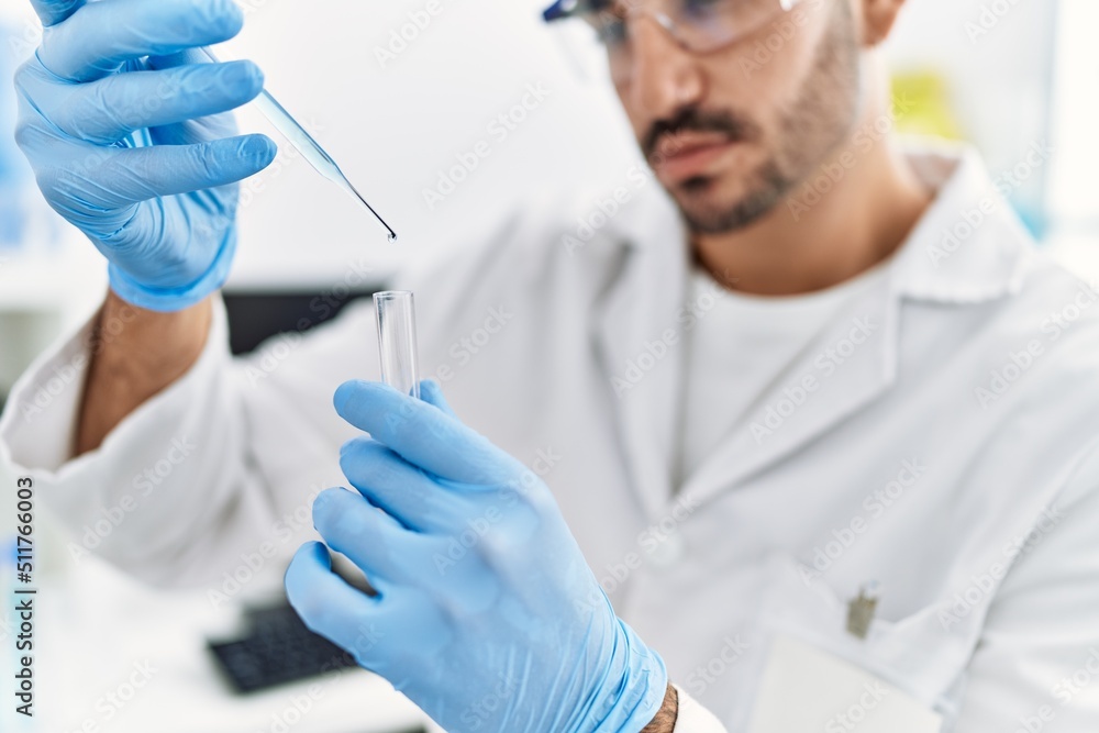 Handsome hispanic man working as scientific holding test tube at laboratory Handsome hispanic man working as scientific holding test tube at laboratory