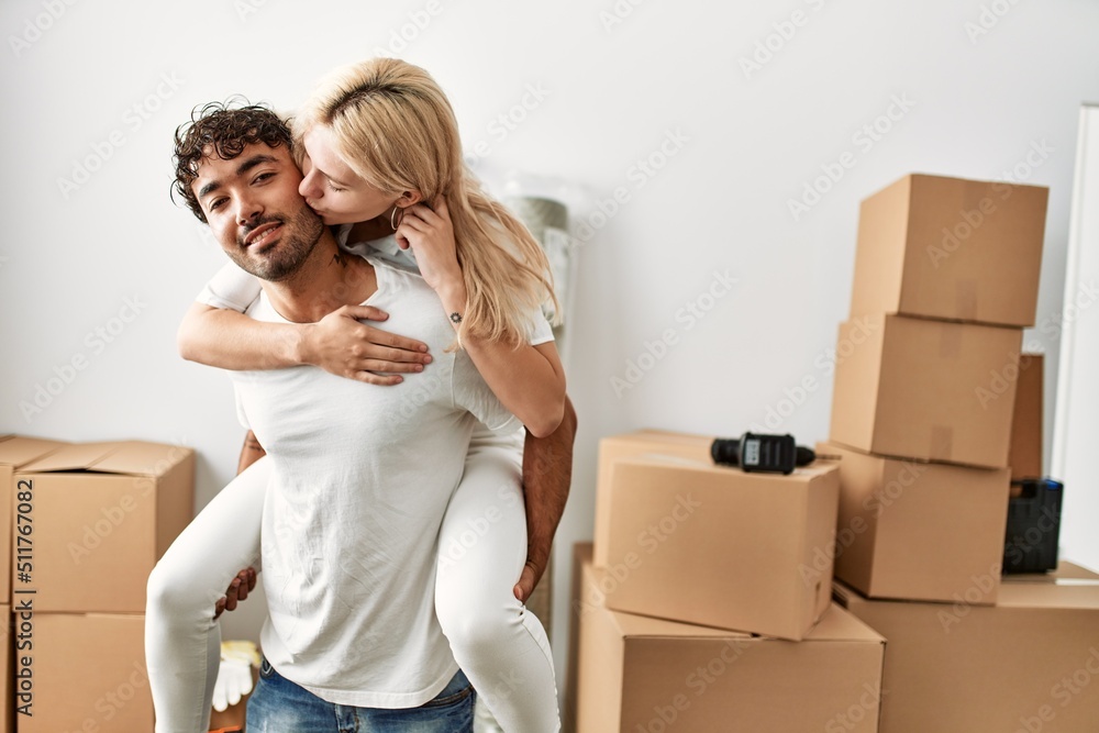 Young man holding woman on his back at new home. Young man holding woman on his back at new home.