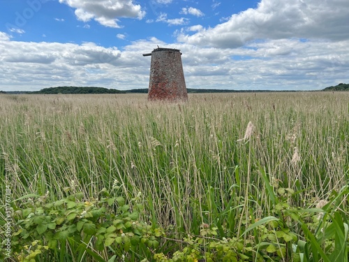 Foto Ancient brick windmill building in nature reserve coastal landscape in Walberswi