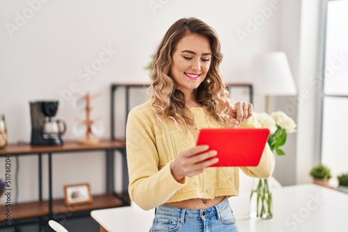 Young woman using touchpad standing at home