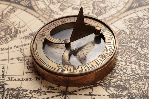 Vintage compass with sundial on old map. Adventure retro style photo