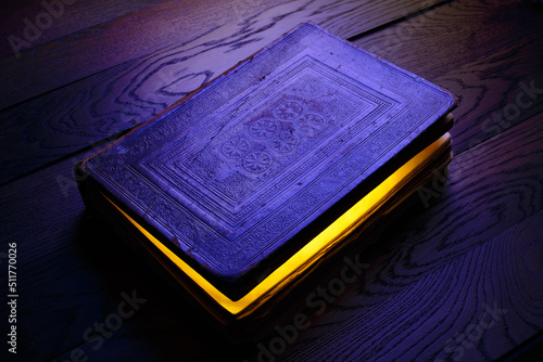 Ancient magic book with light from inside. Mystery night, darkness