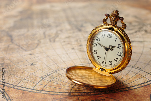 Фотография Ancient gold pocket watch on vintage marine map