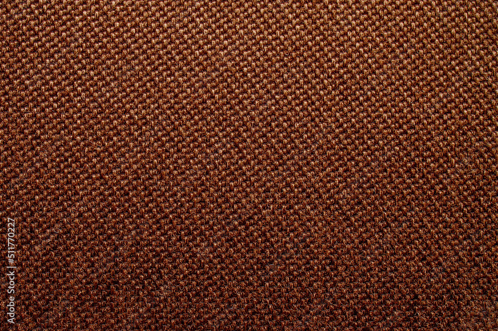 Fototapeta premium Brown background with dense textured fabric for sun blinds or mat, wallpaper, close up. Fabric background