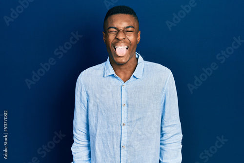 Young african american man wearing casual clothes sticking tongue out happy with funny expression. emotion concept. © Krakenimages.com