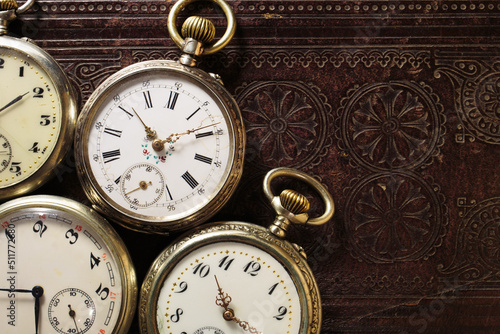 Set of old antique clocks on leather book background