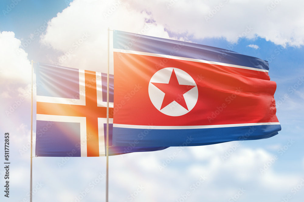 Sunny blue sky and flags of north korea and iceland Sunny blue sky and flags of north korea and iceland
