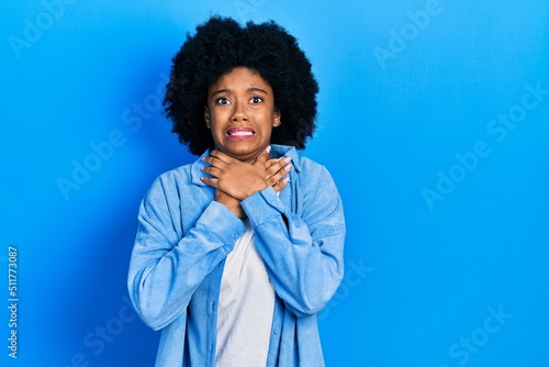 Young african american woman wearing casual clothes shouting suffocate because painful strangle. health problem. asphyxiate and suicide concept.