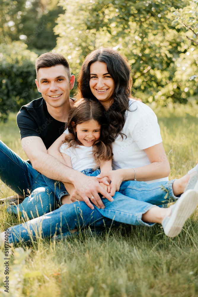 Young cheerful family with daughter having fun outdoors