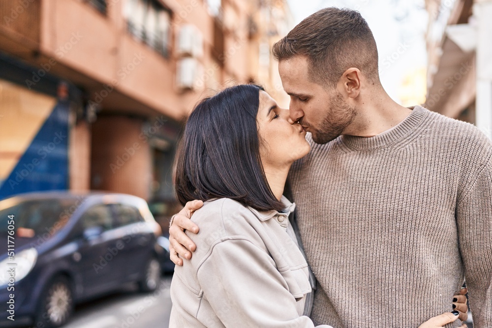 Man and woman couple hugging each other kissing at street Man and woman couple hugging each other kissing at street