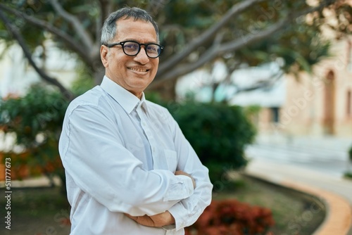Foto Middle age southeast asian man smiling confident with crossed arms by the park
