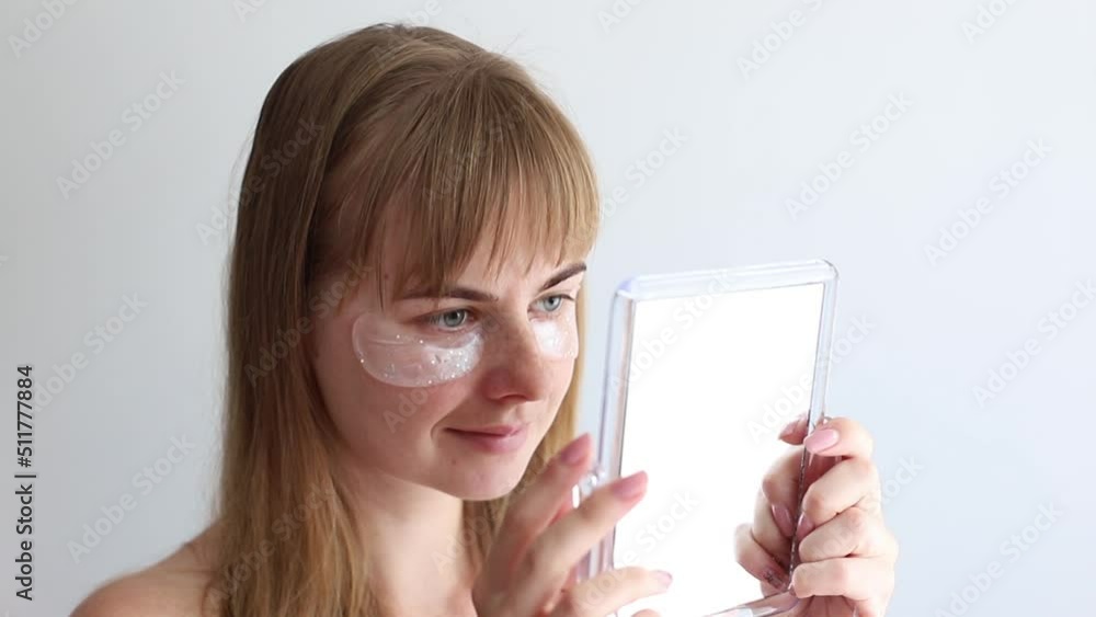 woman in moisturizing patches under the eyes on a white background. close-up woman in moisturizing patches under the eyes on a white background. close-up