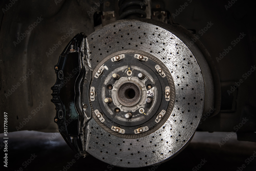 Massive brake caliper on carbon brake disk on a performance car Massive brake caliper on carbon brake disk on a performance car