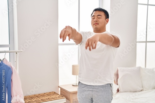 Young chinese man somnambulist sleepwalking at bedroom photo
