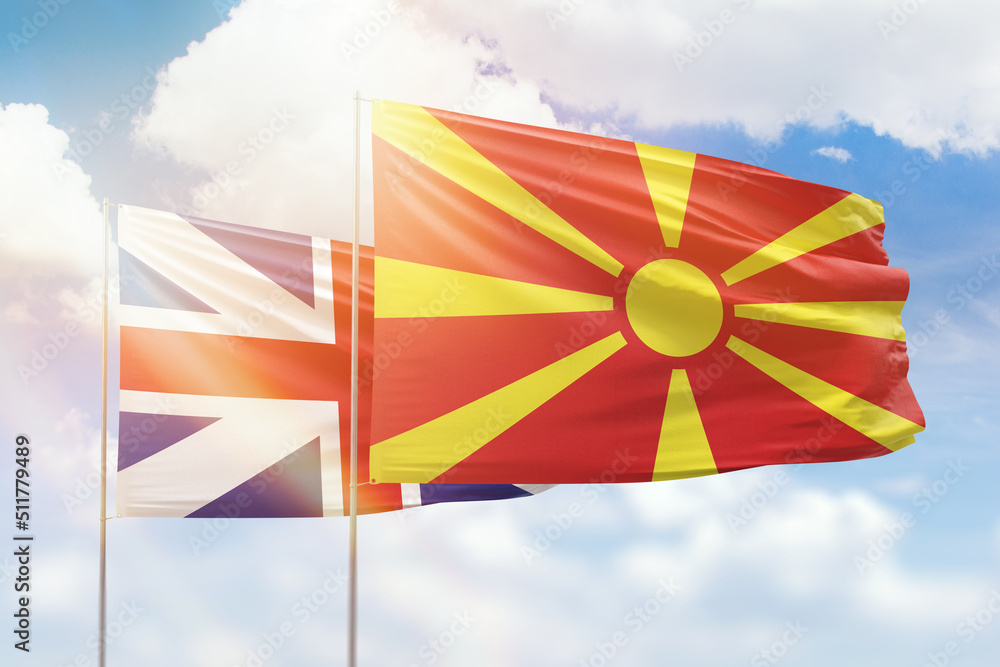 Sunny blue sky and flags of north macedonia and great britain