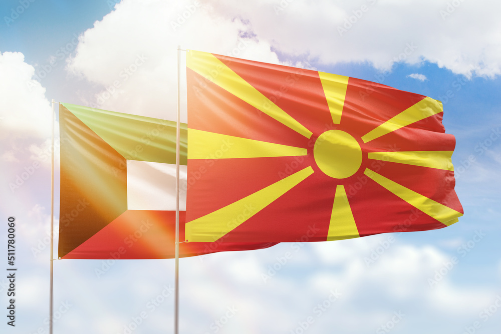 Sunny blue sky and flags of north macedonia and kuwait