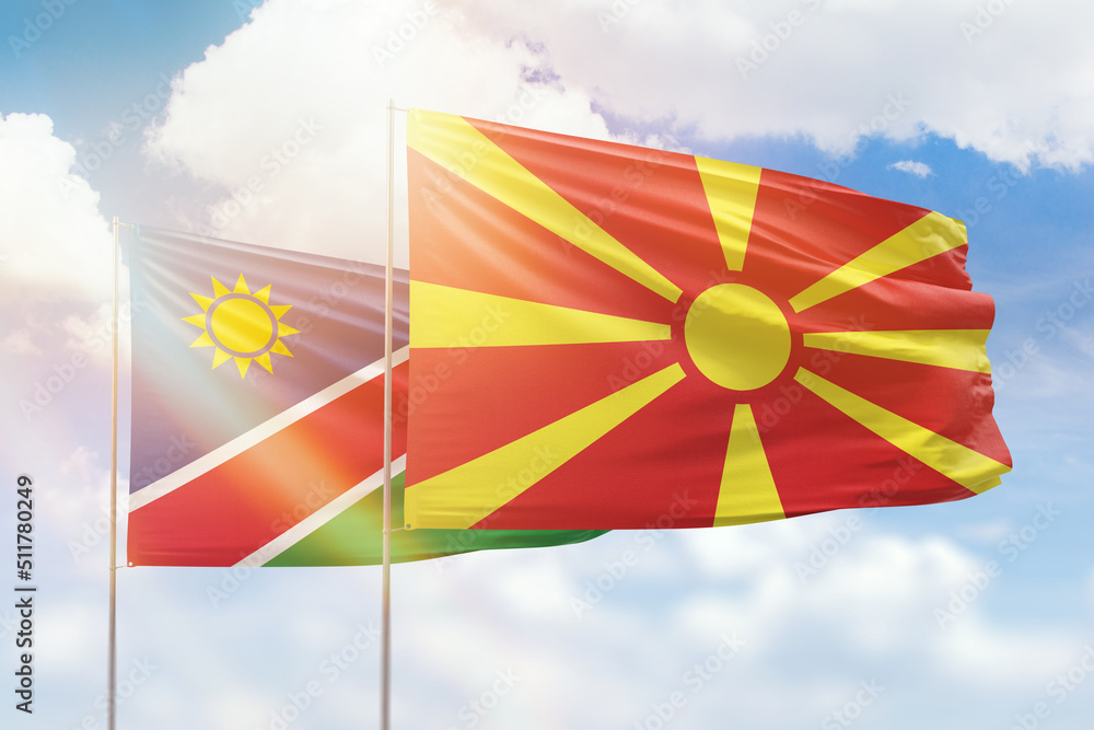 Sunny blue sky and flags of north macedonia and namibia