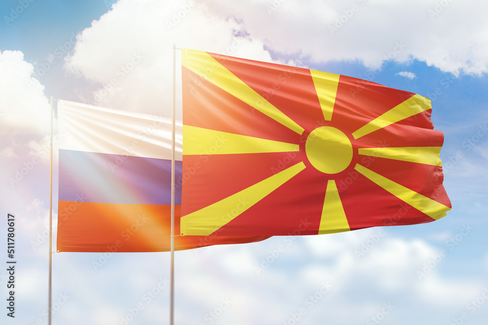 Sunny blue sky and flags of north macedonia and russia