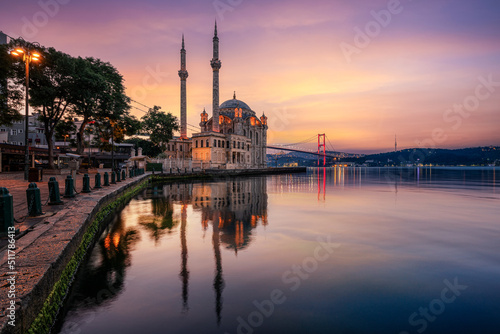 Istanbul. Image of Ortakoy Mosque with Bosphorus Bridge with mirror effect in the water in Istanbul during beautiful sunrise. photo