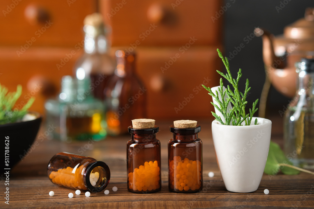 Bottles of homeopathic granules, cabinet with homeopathic remedies and tincture bottles on background. Homeopathy medicine concept. - obrazy, fototapety, plakaty 