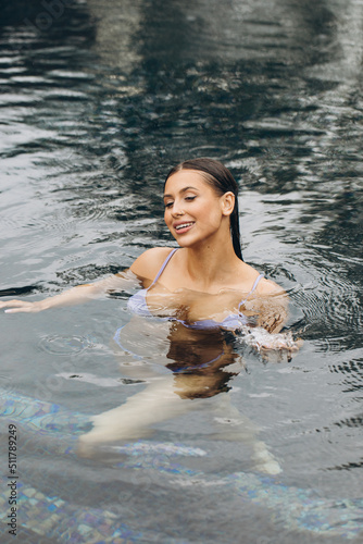 Beautiful and sexy woman in bikini posing in the pool, relaxation concept