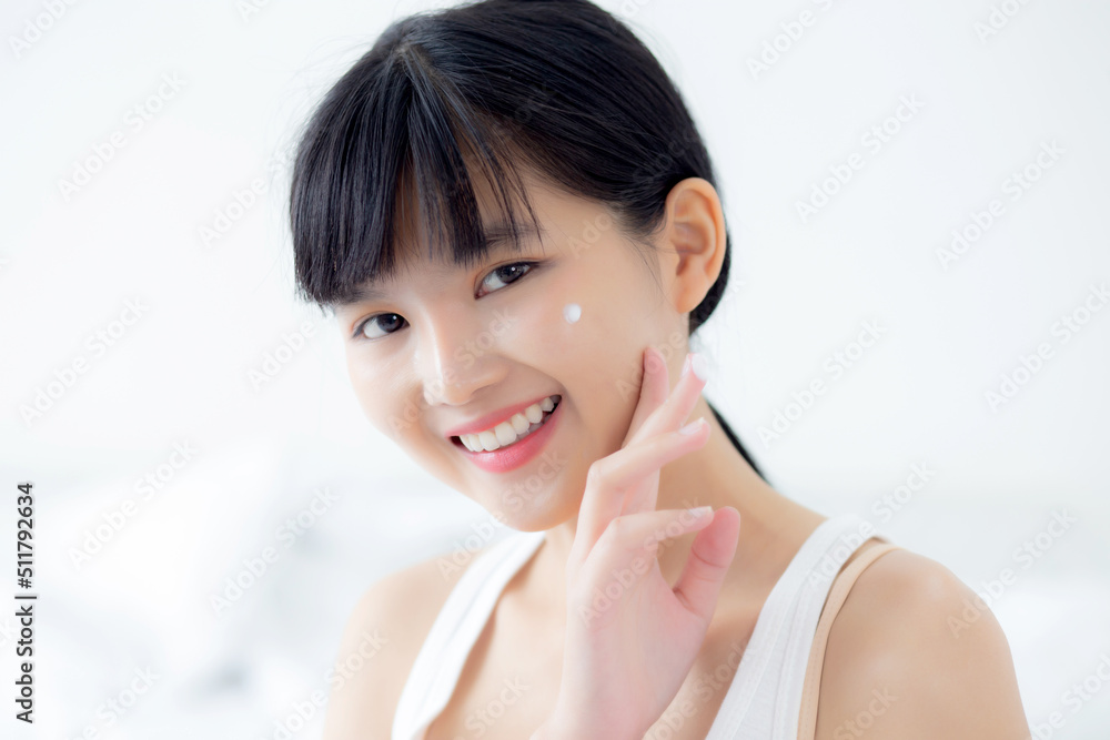 Beautiful young asian woman happy applying cream or lotion with moisturizer to skin on face, beauty asia girl applying skincare touch facial with cosmetic makeup, skin care and health concept. Beautiful young asian woman happy applying cream or lotion with moisturizer to skin on face, beauty asia girl applying skincare touch facial with cosmetic makeup, skin care and health concept.