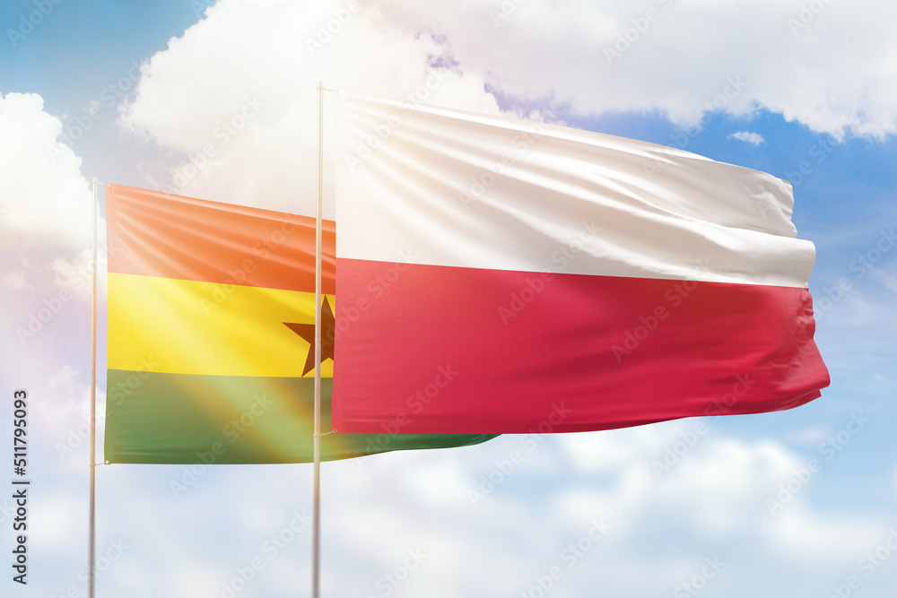 Sunny blue sky and flags of poland and ghana Sunny blue sky and flags of poland and ghana