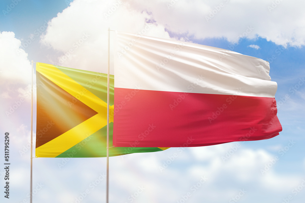 Sunny blue sky and flags of poland and jamaica Sunny blue sky and flags of poland and jamaica