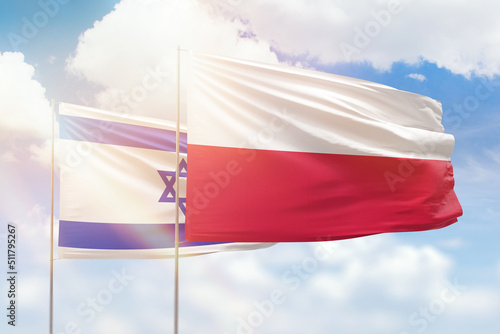 Sunny blue sky and flags of poland and israel