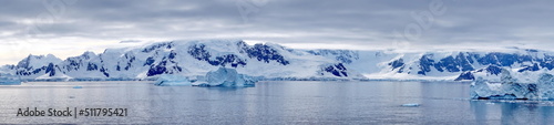 Panorama of icebergs floating in the bay, in front of snow covered moutains at Portal Point in Antarctica © Angela