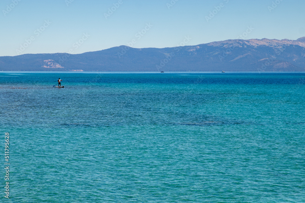 Standup paddleboarder enjoys the blue water of Lake Tahoe
