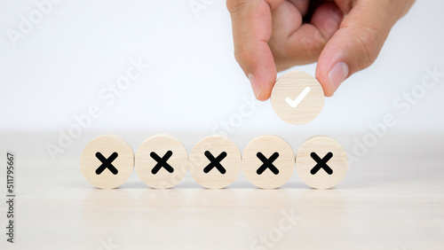 Hand choose check mark on wooden toy with cross symbol for true or false changing mindset or way of adapting to change leader and transform quiz answer and poll concept. photo