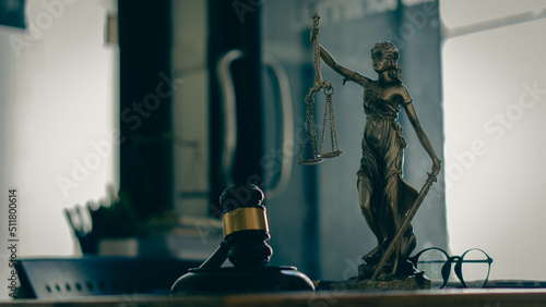 Law concept  hammer  and goddess of injustice  law tiger  and laptop on a table in a lawyer s office.
