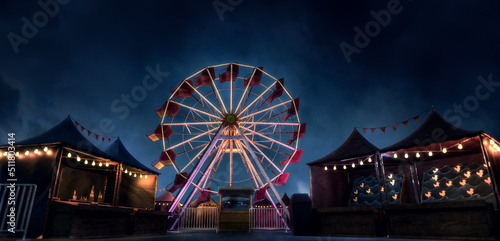 Foto Old carnival with a ferris wheel on a cloudy night