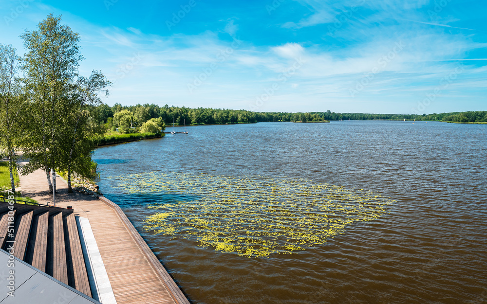 view of the paprocańskie lake in Tychy. Wooden platforms in the foreground. Water plants and sailboats. A beautiful sunny day. Canoe harbor view of the paprocańskie lake in Tychy. Wooden platforms in the foreground. Water plants and sailboats. A beautiful sunny day. Canoe harbor