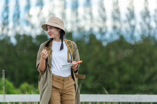 People young woman traveler and tourism holding map and pointing trips travel on hatchback car to destination leisure travel on the road forest in holiday vacations. Happy and Enjoy trip adventure.