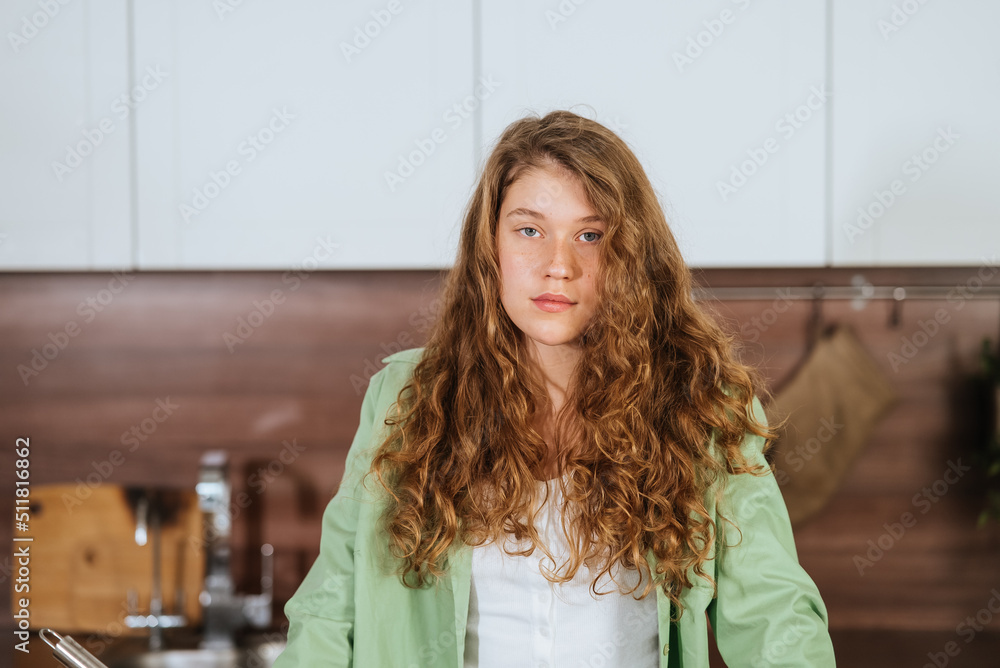 Close up portrait of a happy smiling woman on kitchen looking directly at the camera