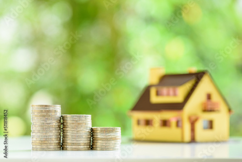 Obraz na plátně Mortgage loan or home equity loan, financial concept : Model residential house and coins or money on a table, depicting home loan or borrowing money to purchase a new home for first time homebuyer
