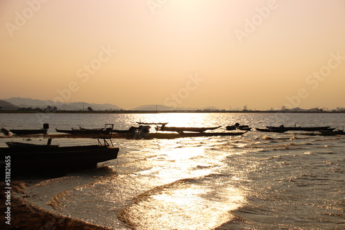 Sunset silhouettes of fishing boats in Lak Lake in the township of Lien son  Dak Lak Vietnam