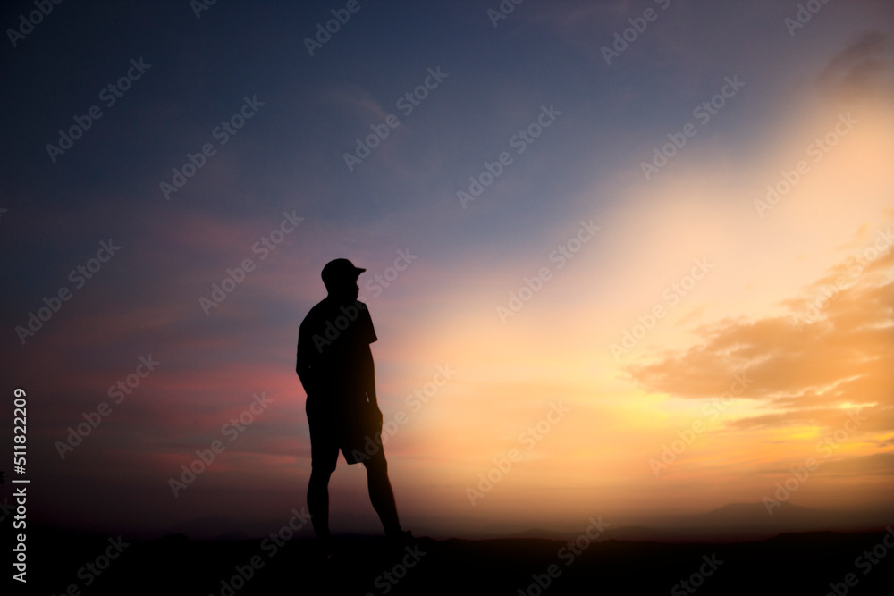 silhouette of a man standing on a rock