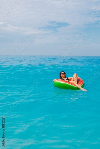 sexy woman swimming in blue sea on inflatable ring © phpetrunina14