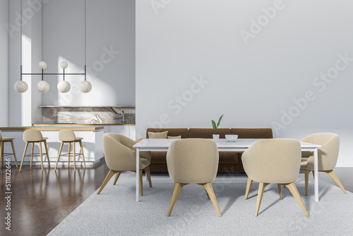 Light kitchen interior with eating table and couch, bar chairs. Mockup wall