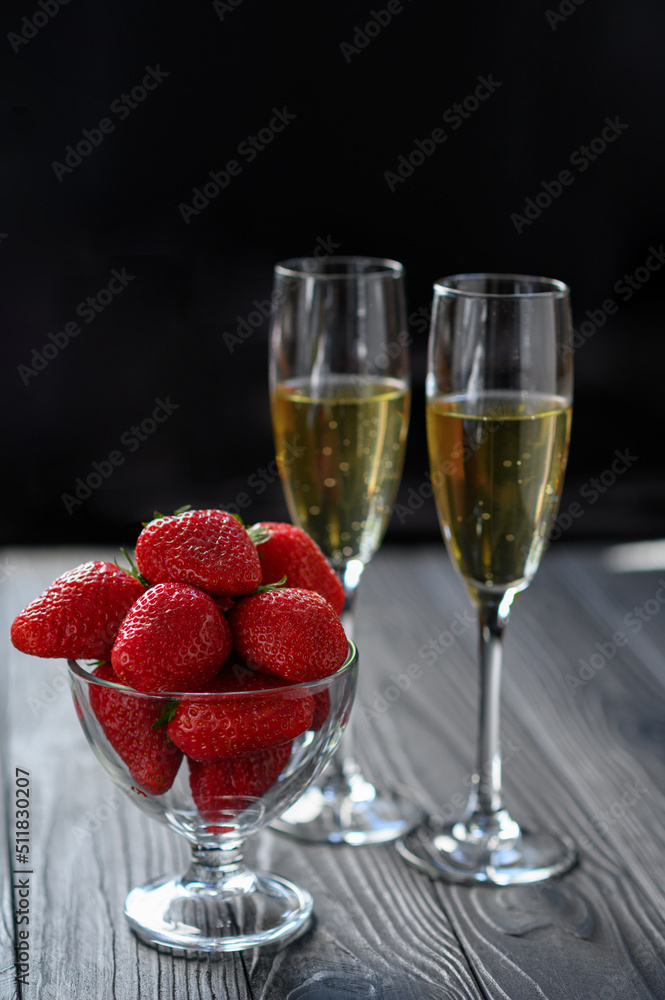 strawberries and champagne in a glass on a black background strawberries and champagne in a glass on a black background